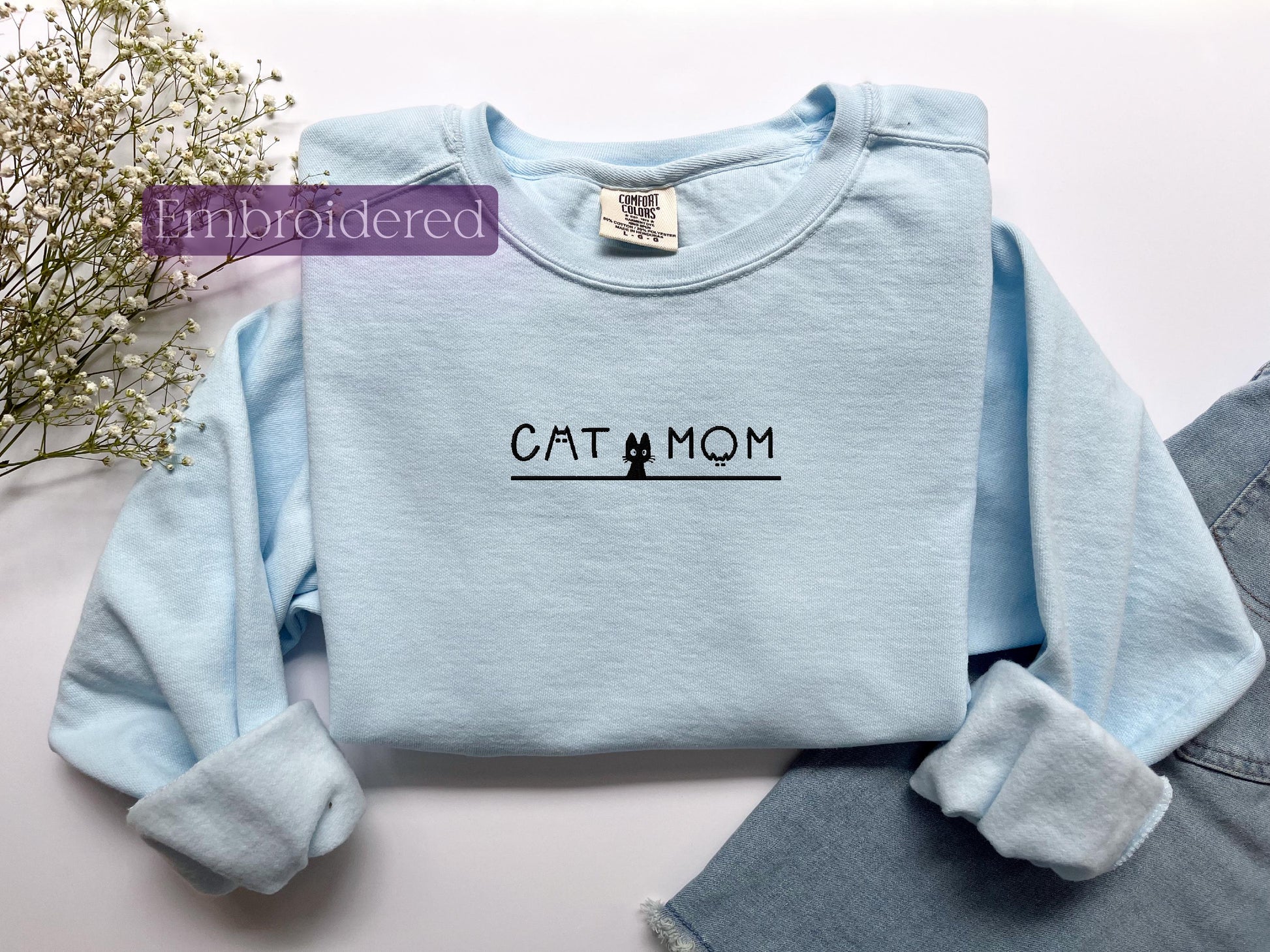 a blue shirt with the word cat mom on it