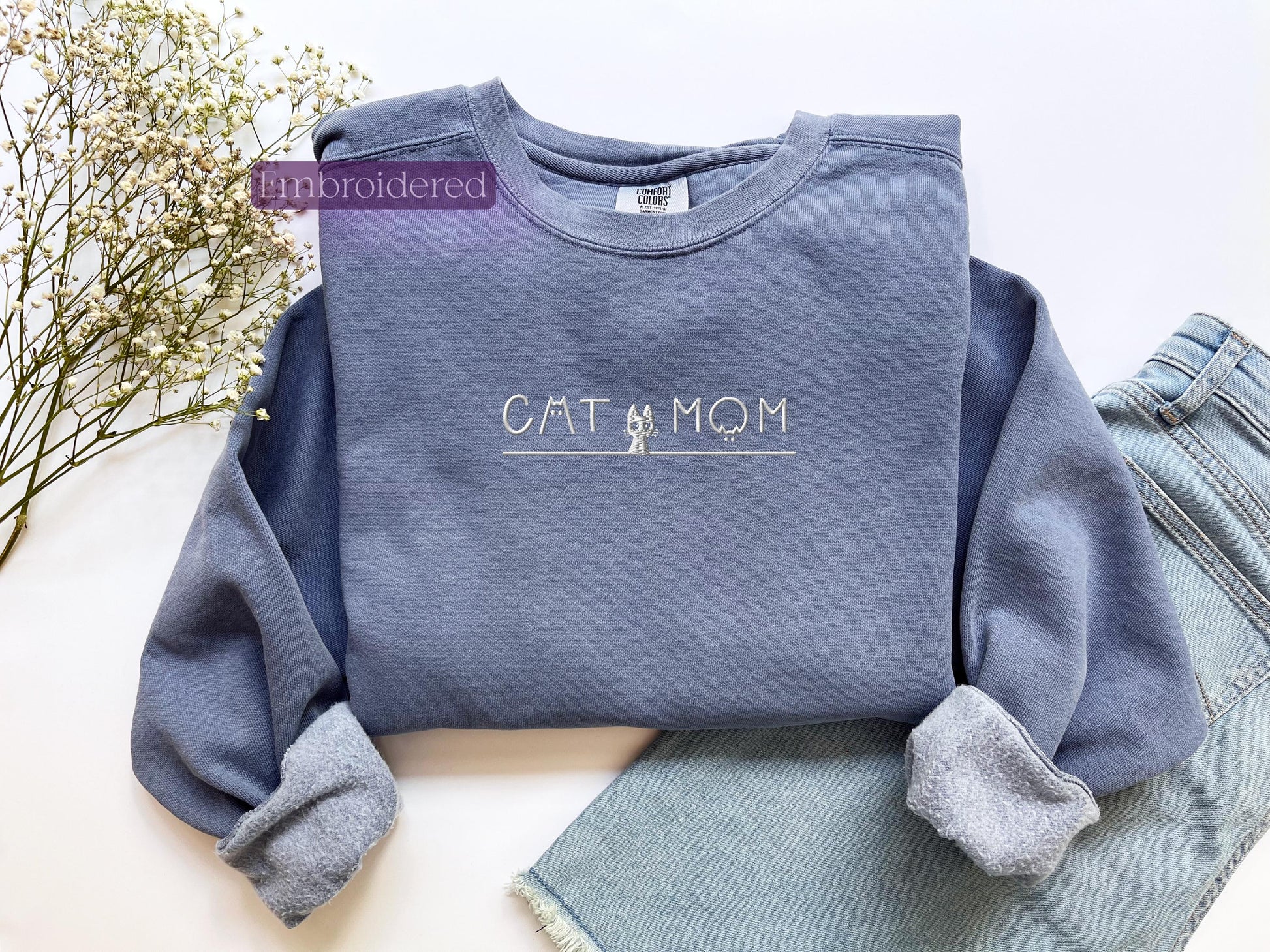 a blue sweatshirt with the word cat mom on it