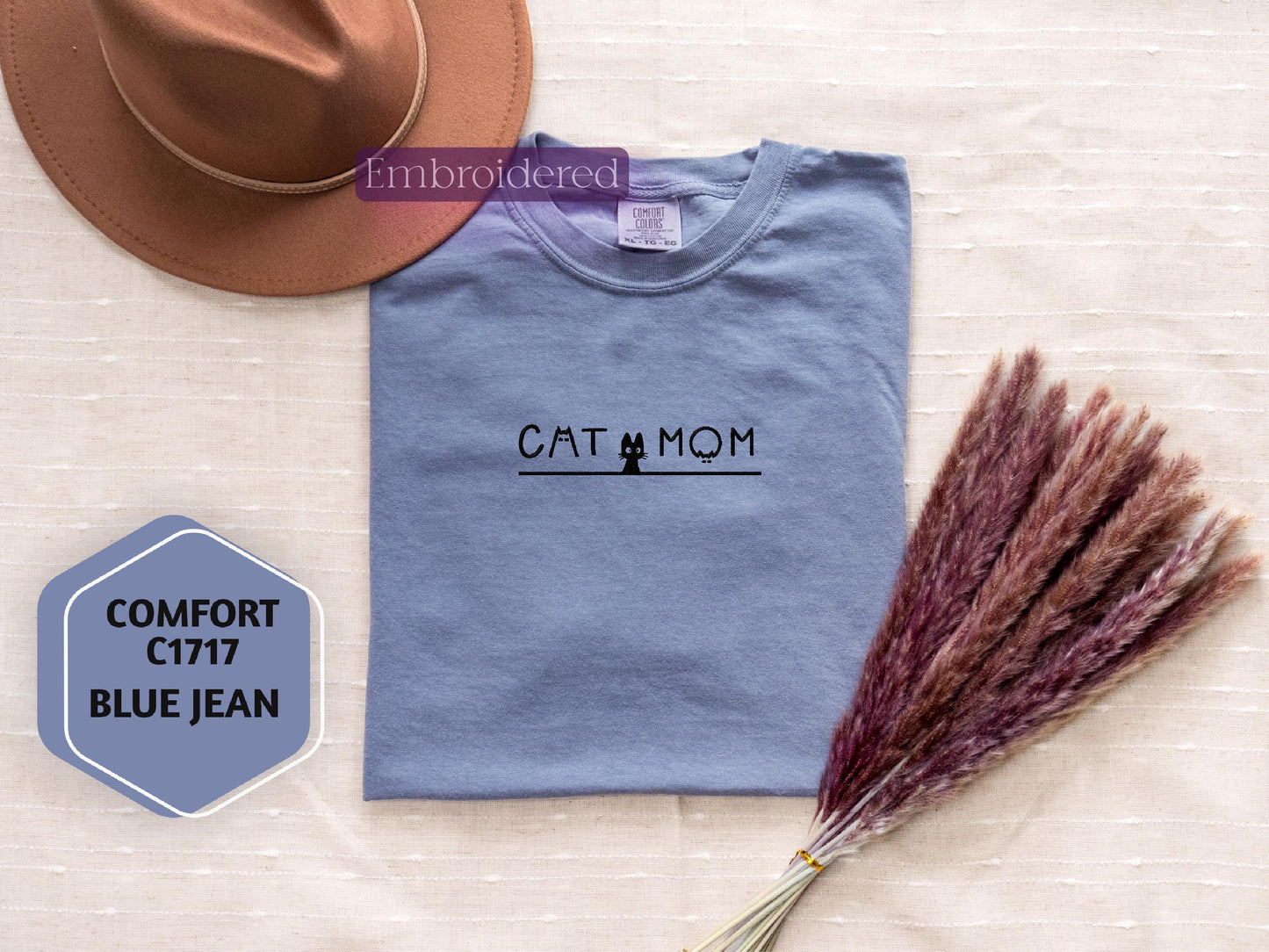 a t - shirt that says cat and mom next to a hat