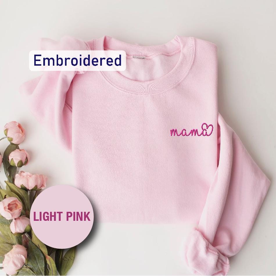 a pink sweater with the word pink embroidered on it