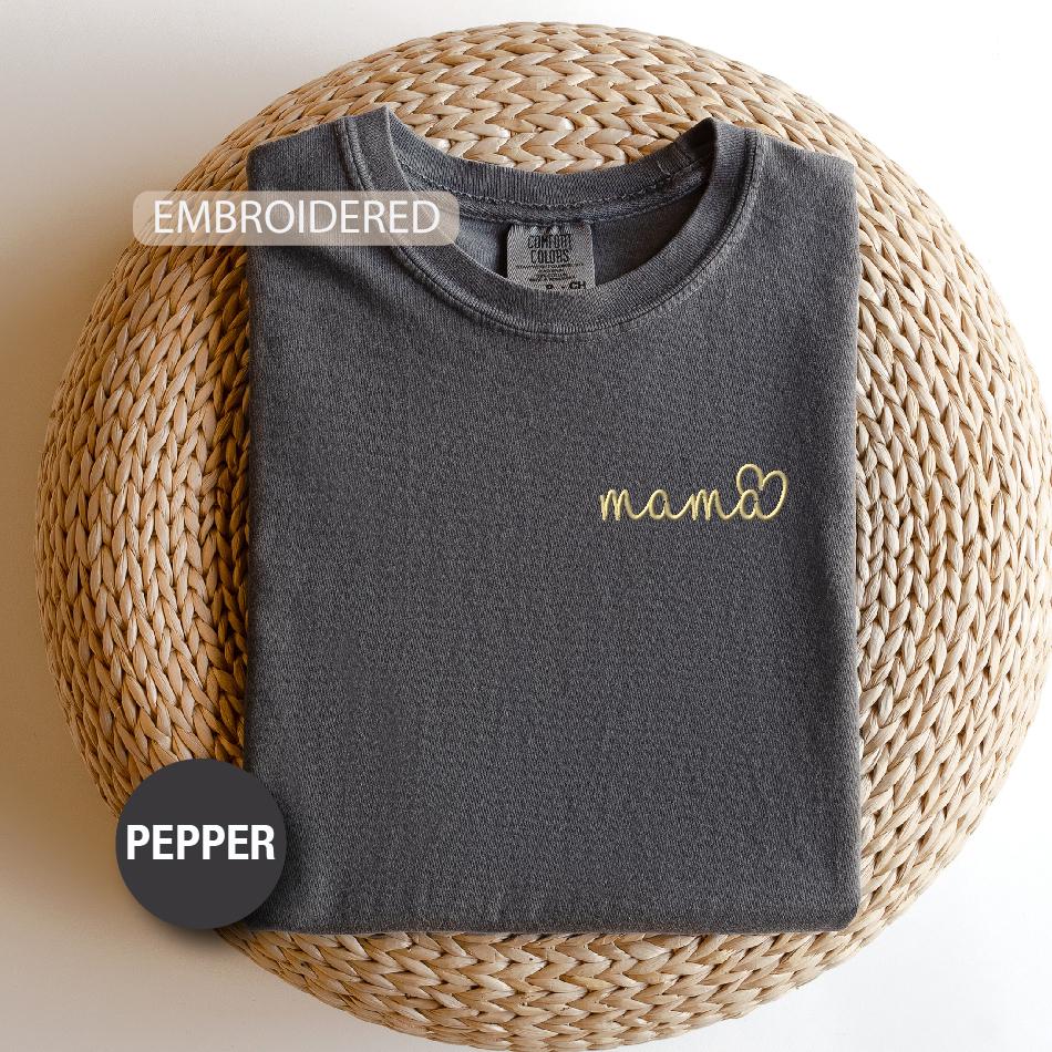 a t - shirt with the word mama on it next to a woven basket