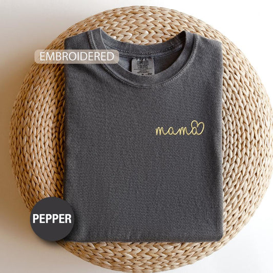a t - shirt with the word mama on it next to a woven basket