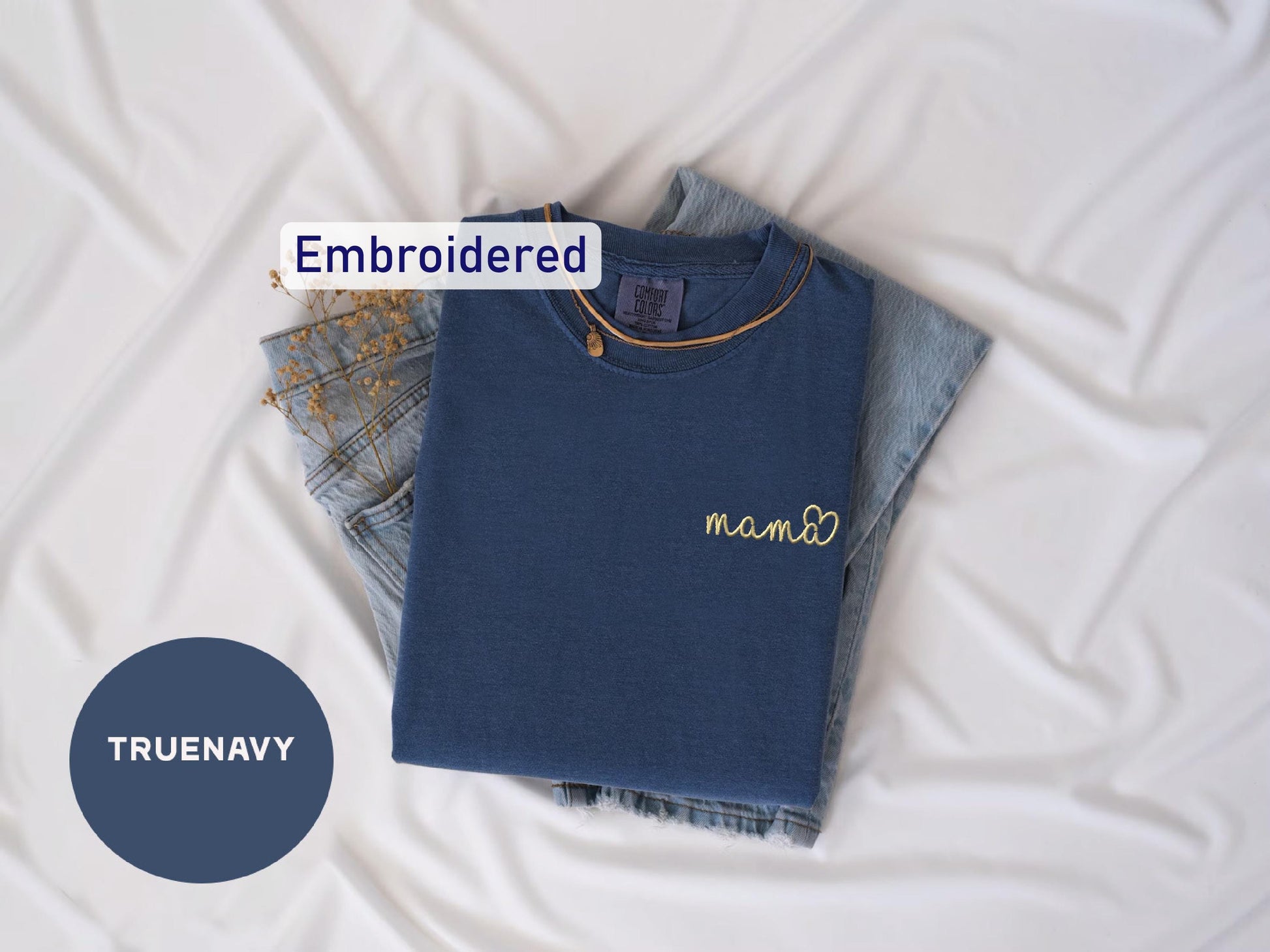 a blue shirt with a name on it next to a pair of jeans