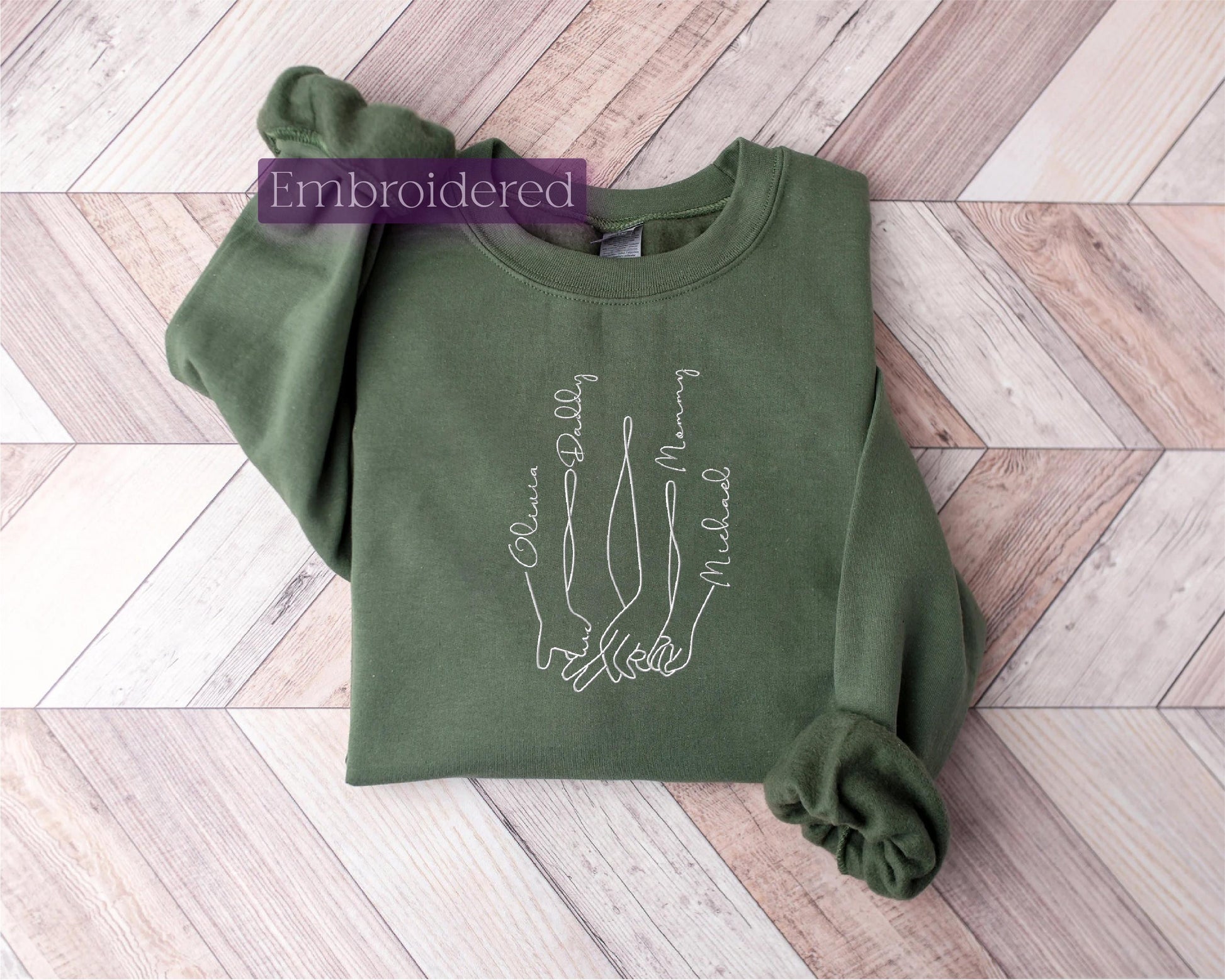 a green sweatshirt with a picture of two hands on it