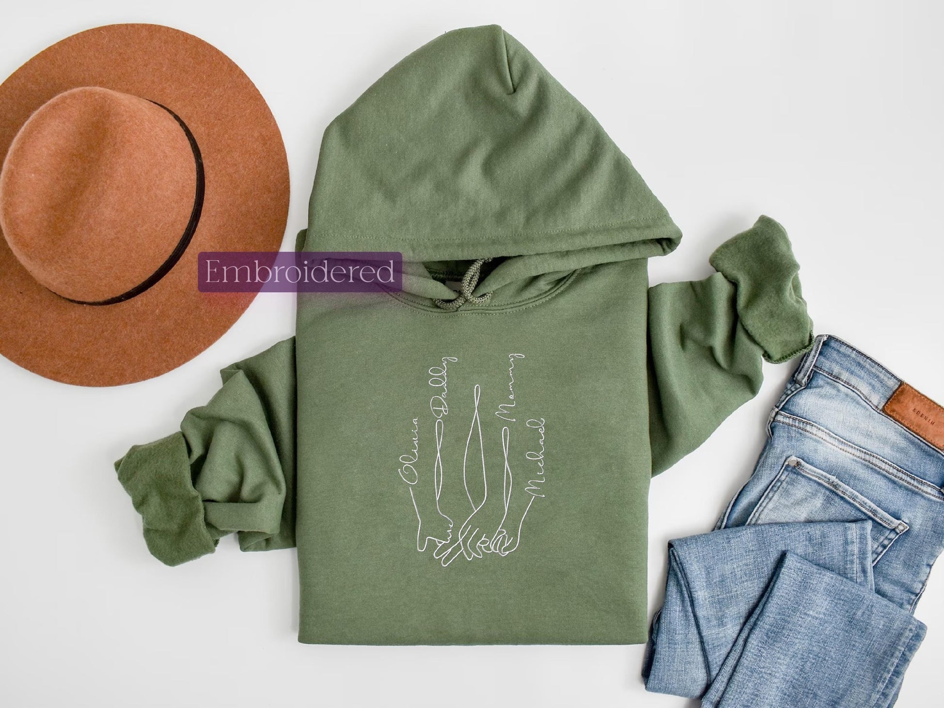 a green hoodie, jeans, hat, and a pair of shoes