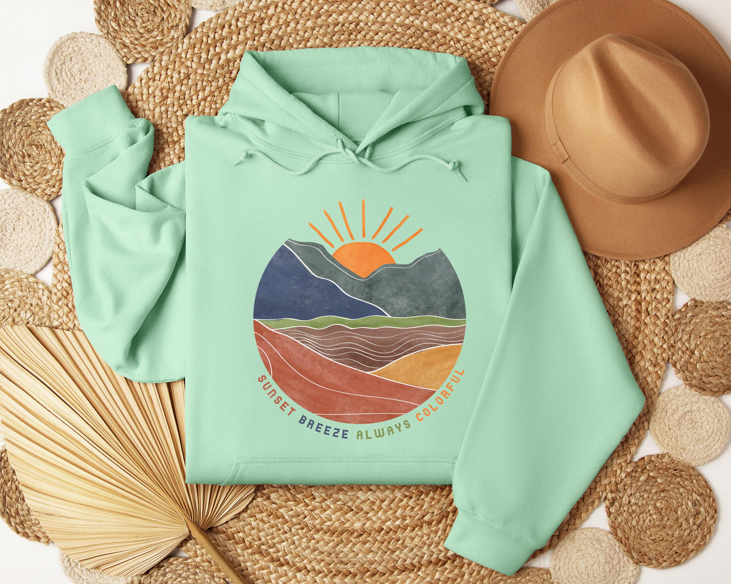 a green hoodie with a mountain scene on it