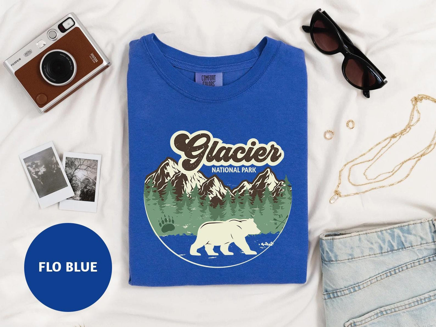 a t - shirt with a polar bear on it next to a pair of sunglasses