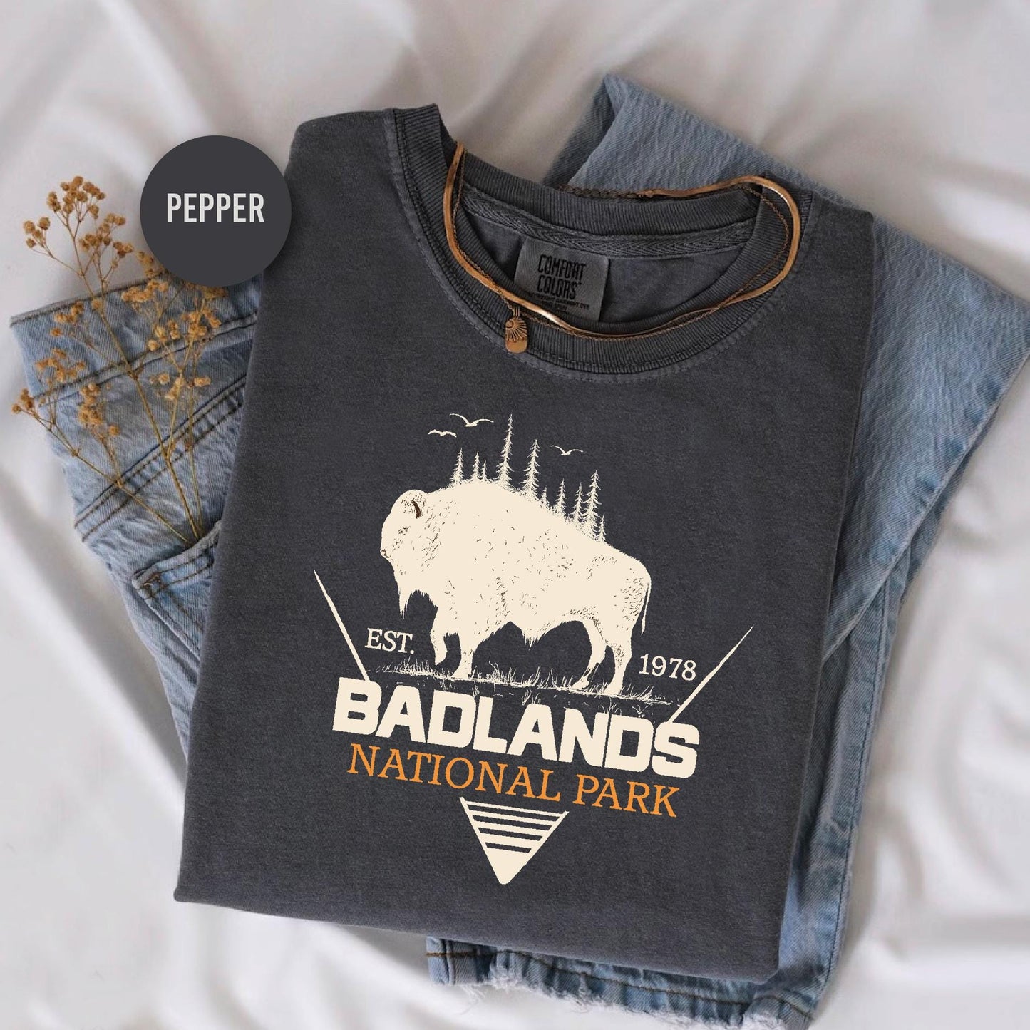 a t - shirt with a buffalo on it sitting on a bed