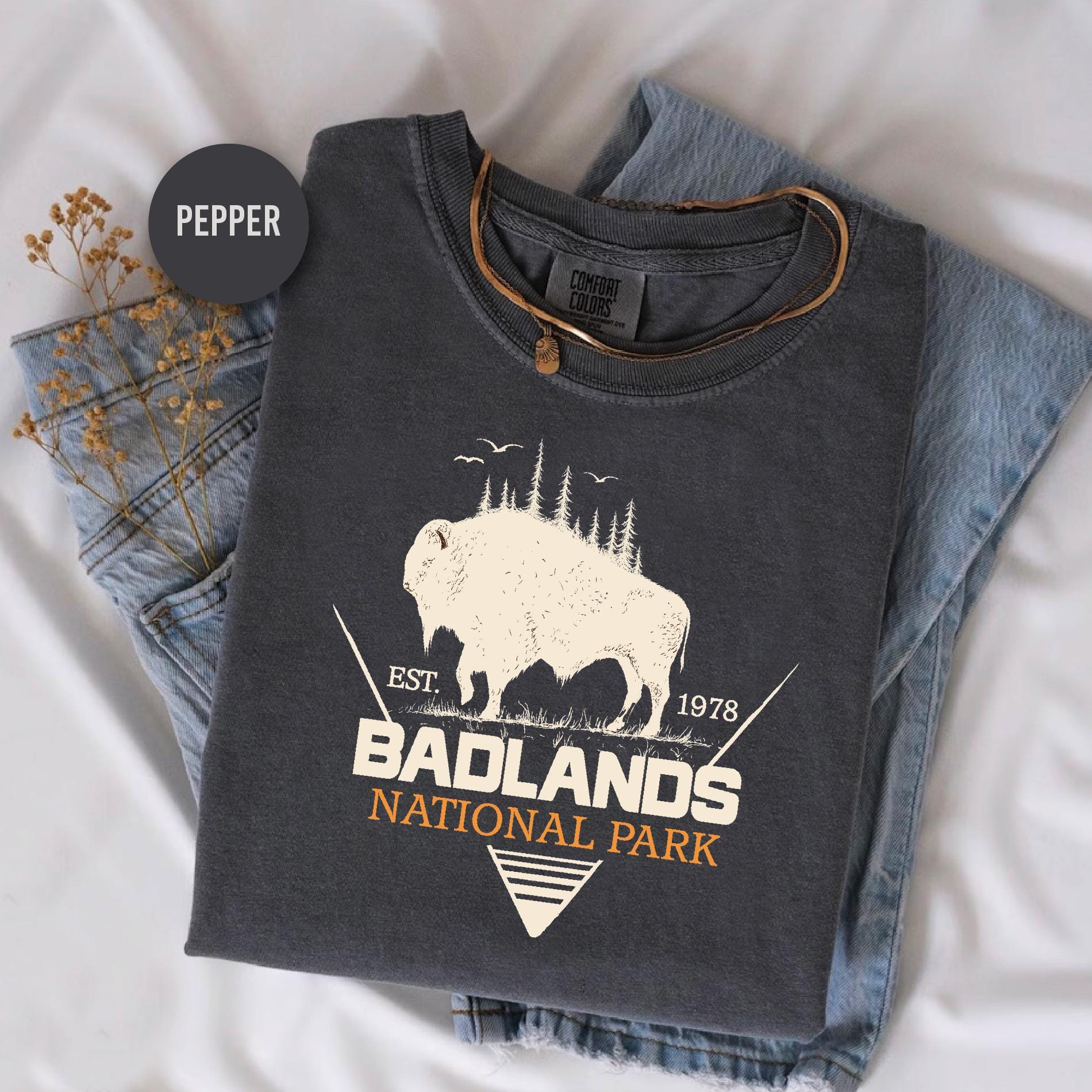 a t - shirt with a buffalo on it sitting on a bed