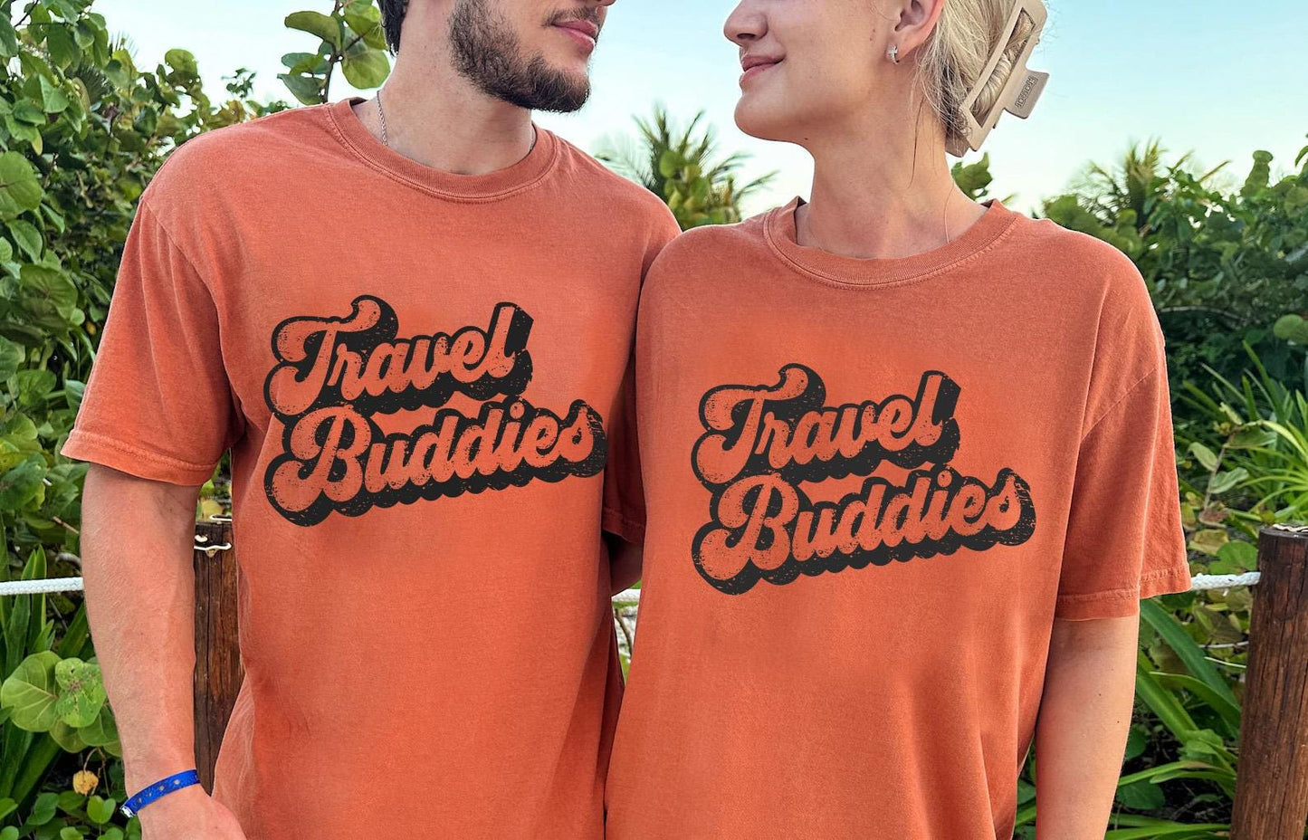 a man and a woman wearing travel buddies t - shirts