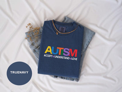 a t - shirt that says autism on it next to a pair of jeans