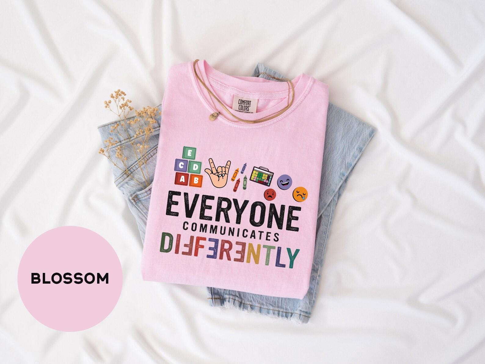 a pink shirt that says everyone communicate differently