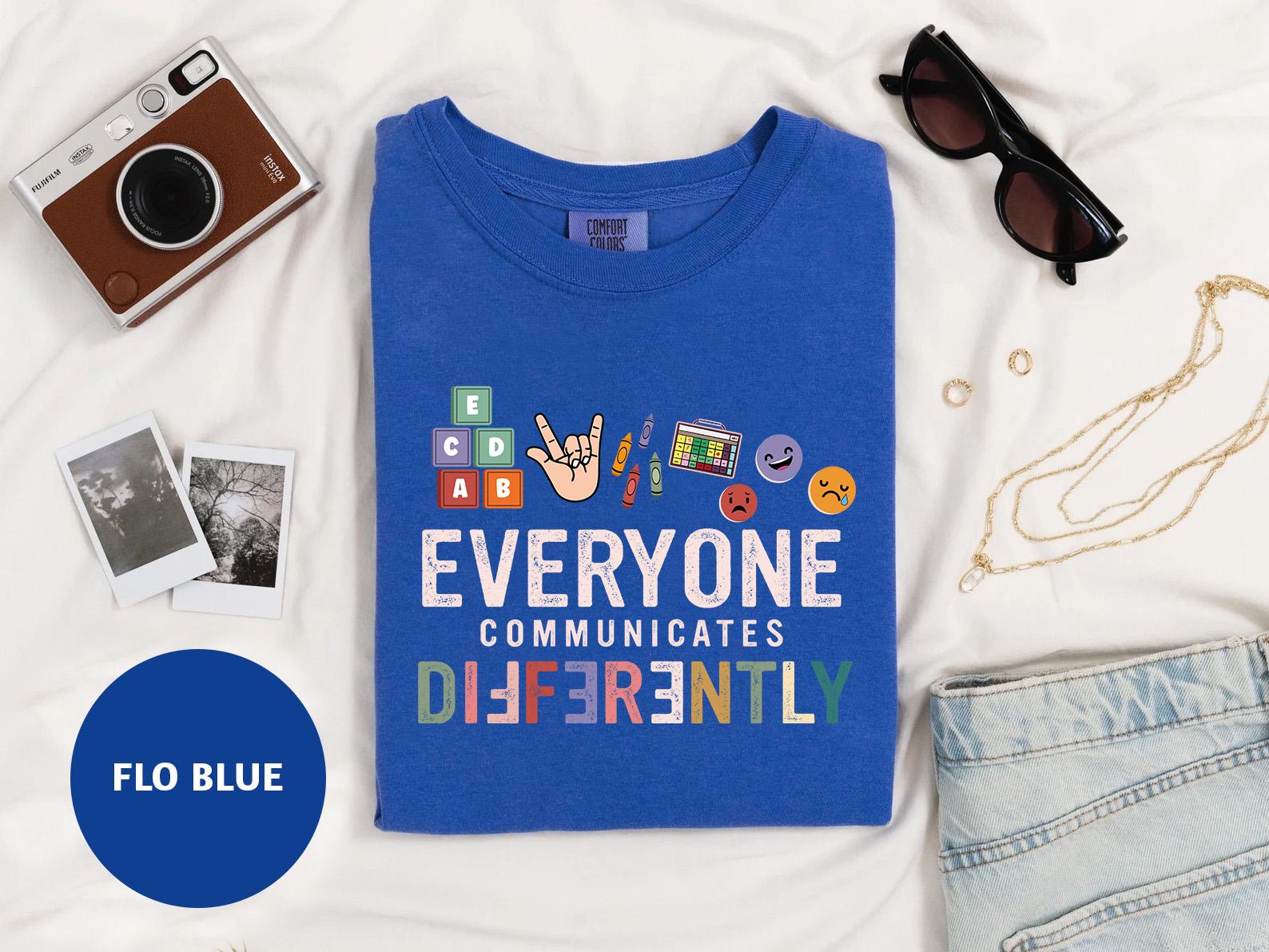 a blue t - shirt with the words everyone communicate differently on it