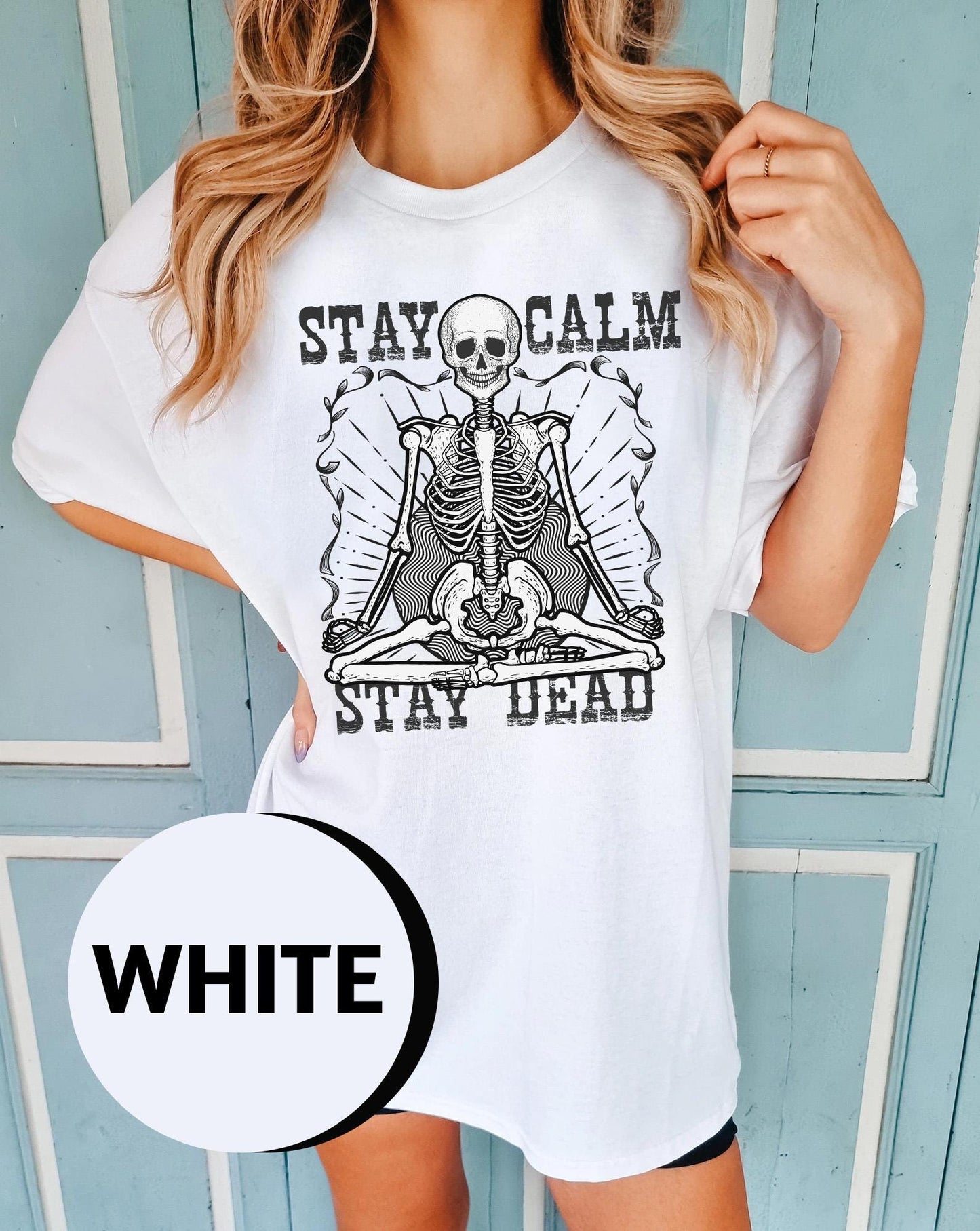 a woman wearing a white t - shirt that says stay calm stay dead