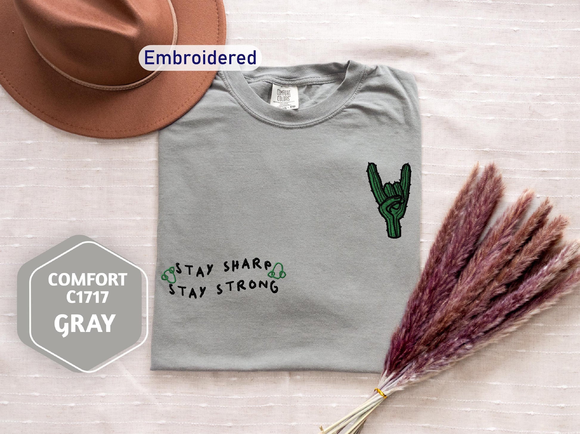 a t - shirt with a cactus on it and a straw hat next to it