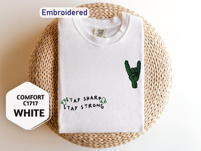 a white shirt with a cactus embroidered on it