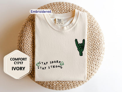 a white t - shirt with a cactus embroidered on it