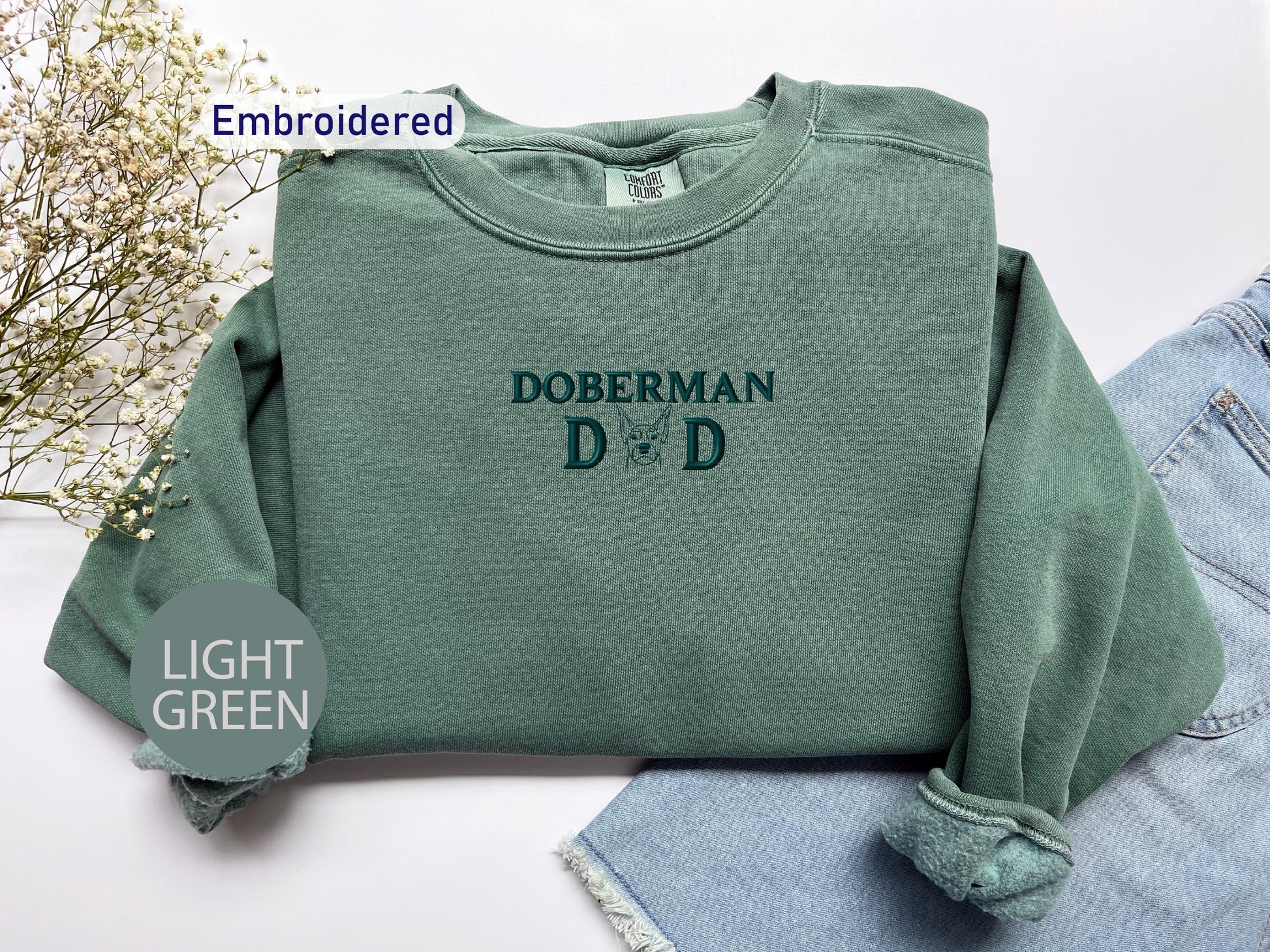 a green sweatshirt with the words dobermann d on it