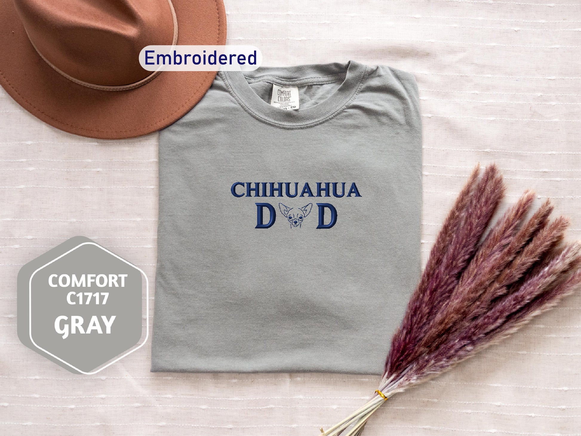 a hat, a t - shirt, and a dried plant on a bed