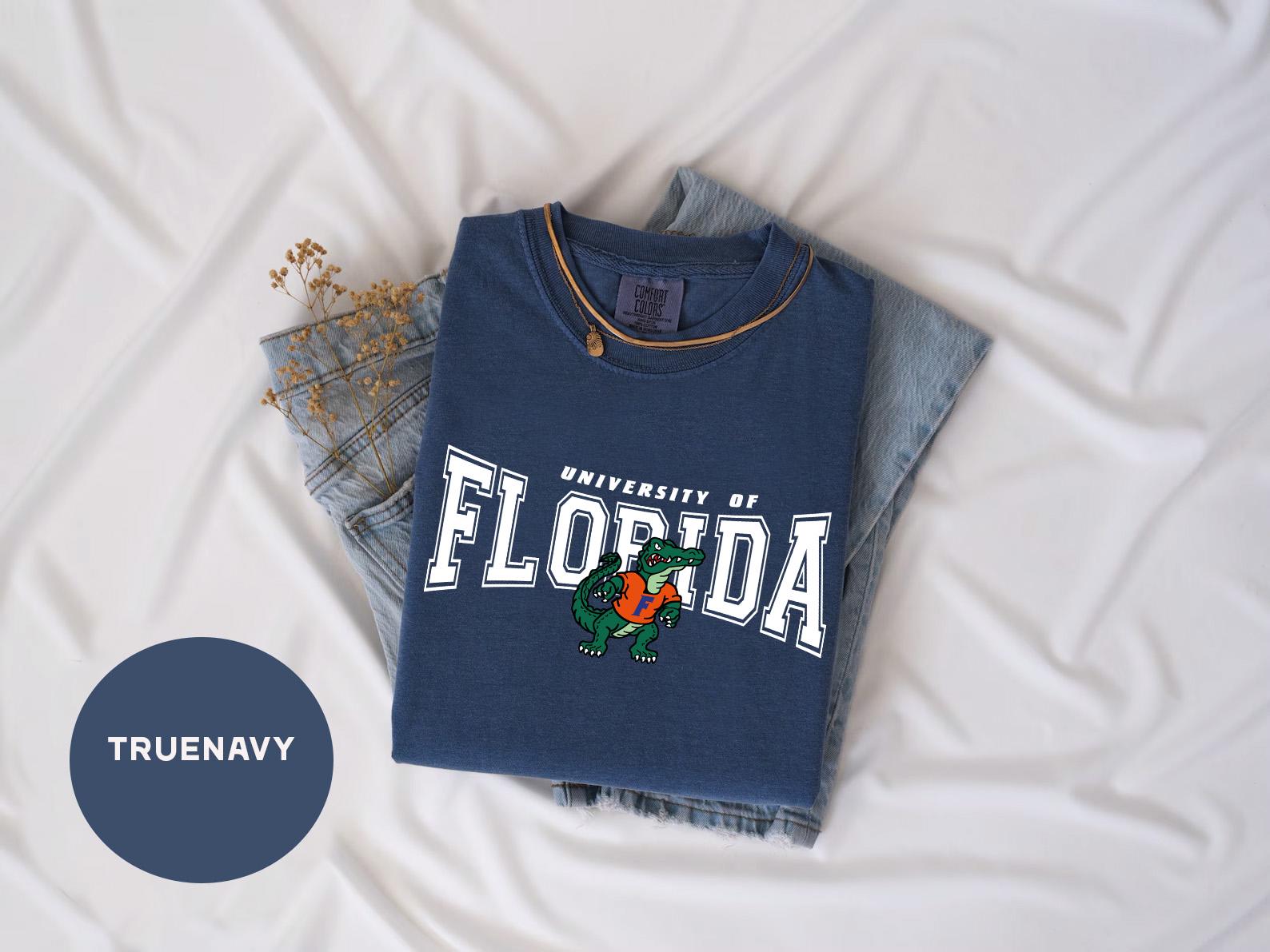 a t - shirt that says university of florida on it next to a pair of