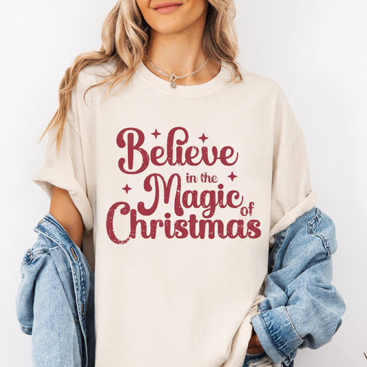 a woman wearing a t - shirt that says believe in the magic of christmas