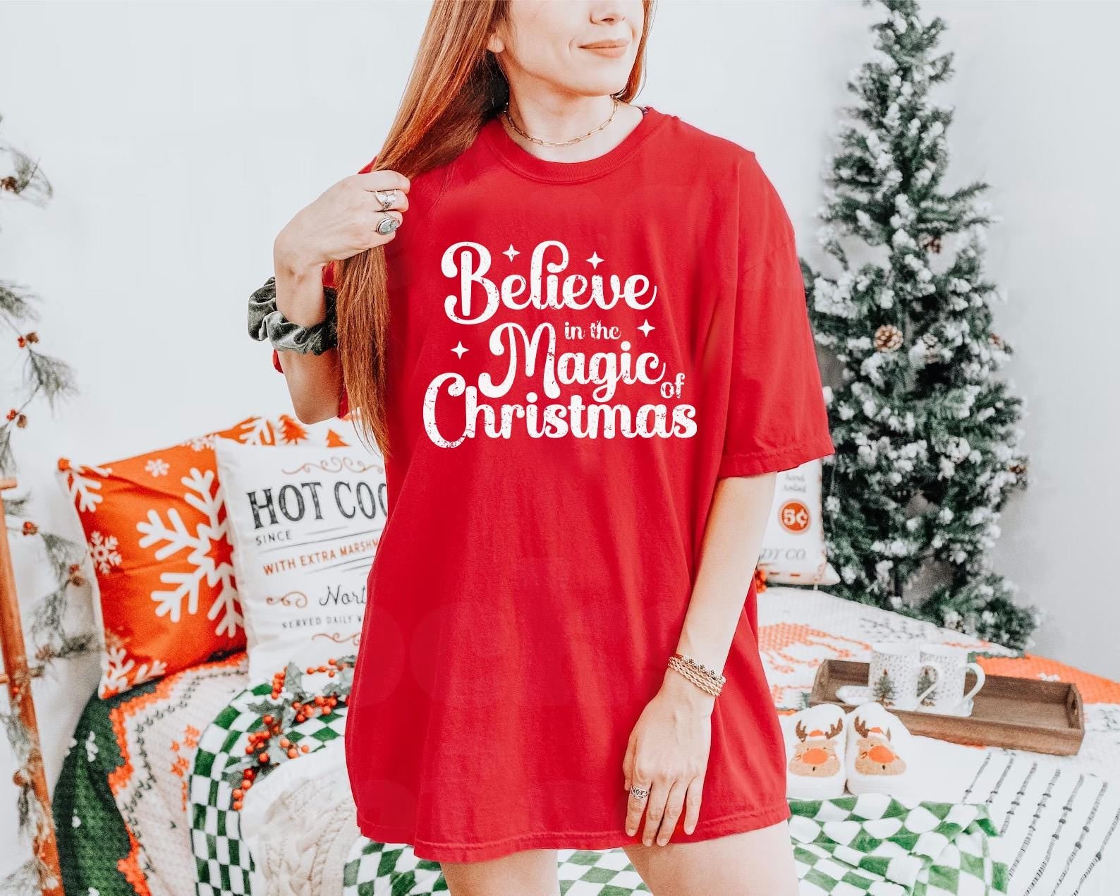 a woman wearing a red t - shirt that says believe to the magic of christmas