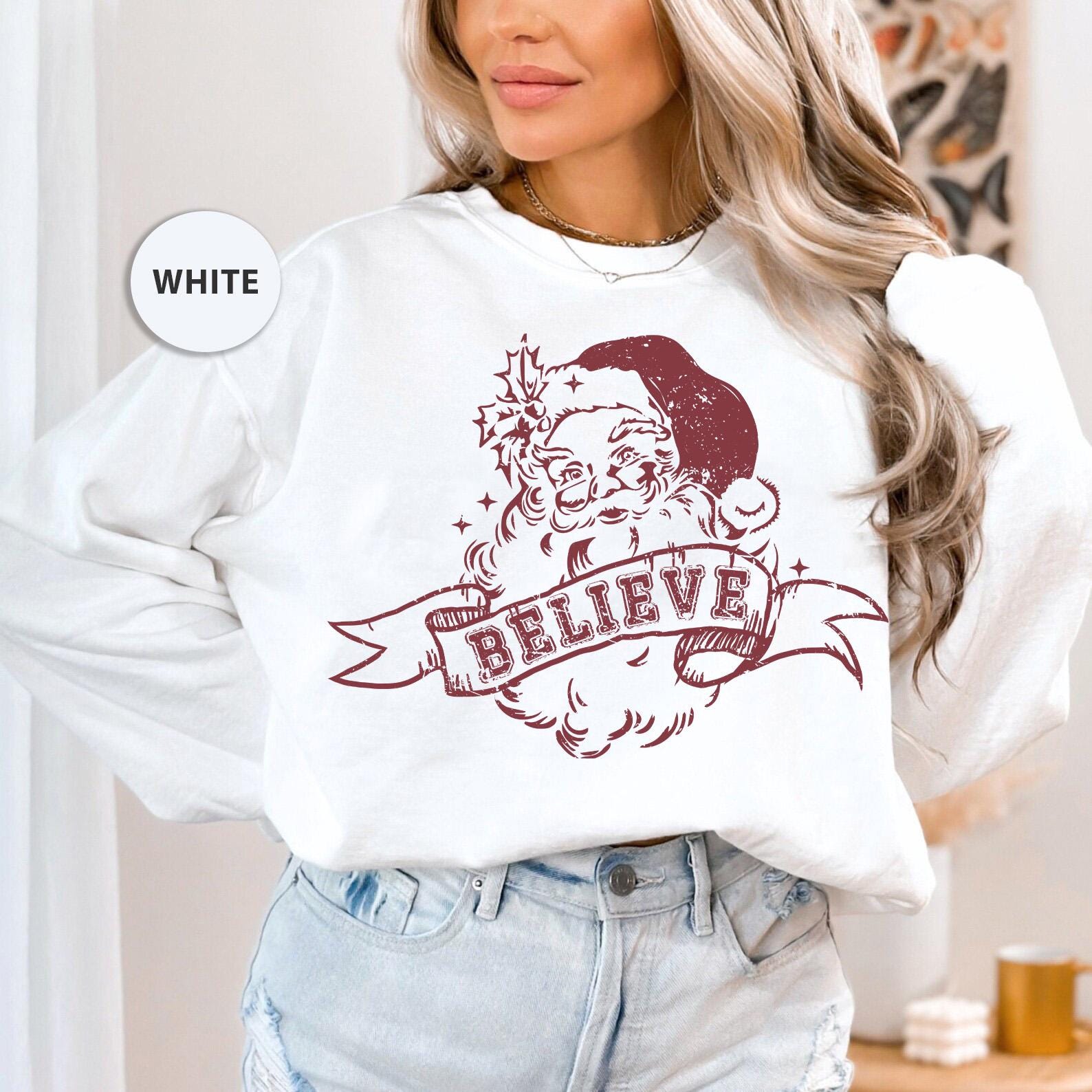 a woman wearing a white sweatshirt with a santa clause on it