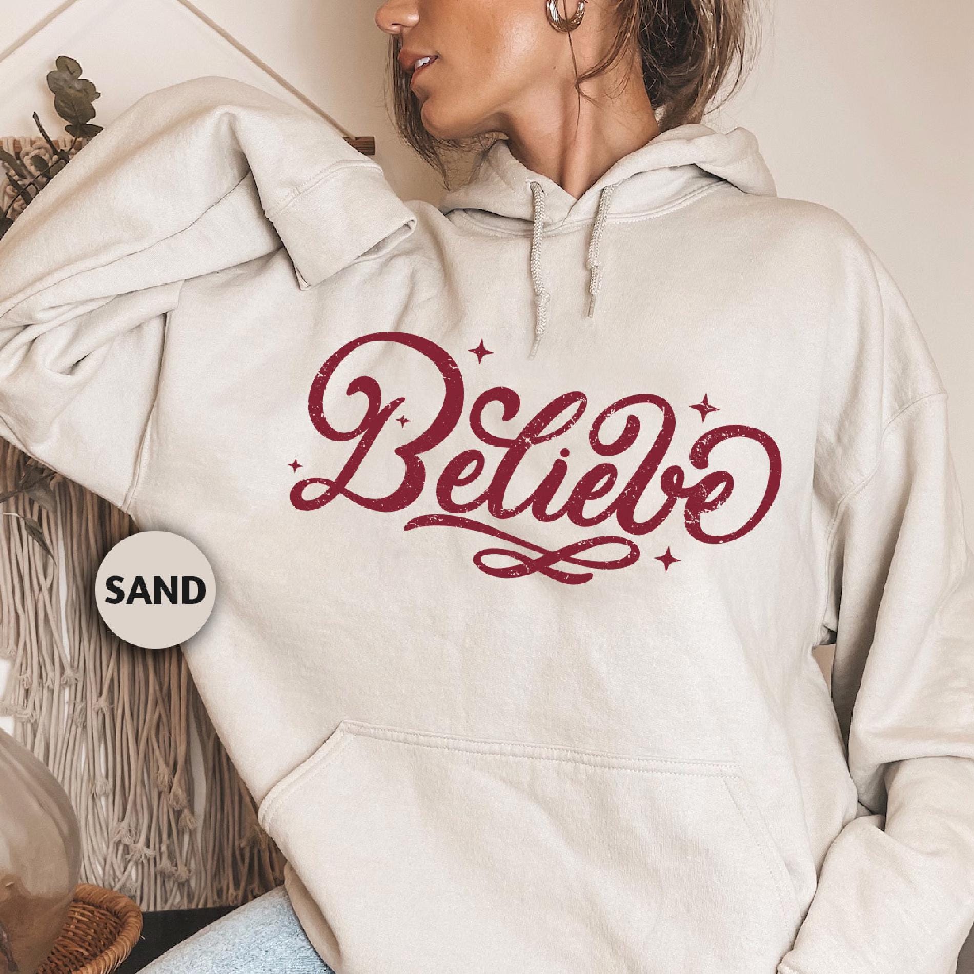 a woman wearing a white hoodie with the word believe on it