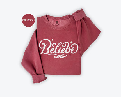 a red sweatshirt with the words believe on it