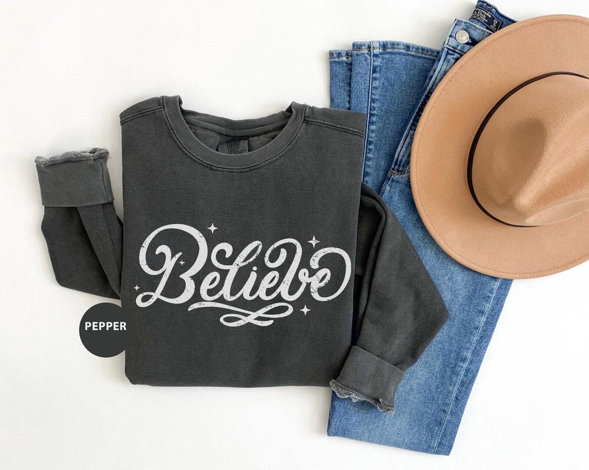 a hat, jeans, and sweatshirt with the word believe on it