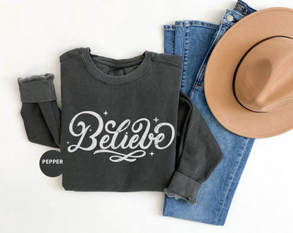 a hat, jeans, and sweatshirt with the word believe on it