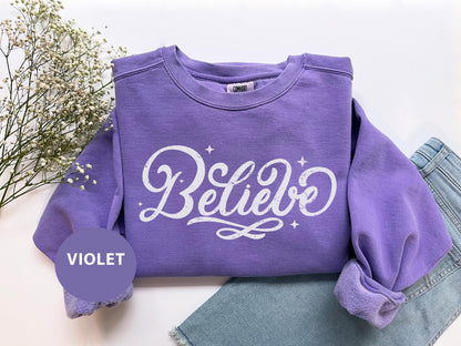 a purple sweatshirt with the word believe on it