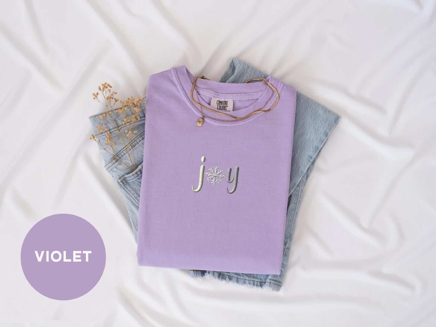 a purple t - shirt with the word joy on it